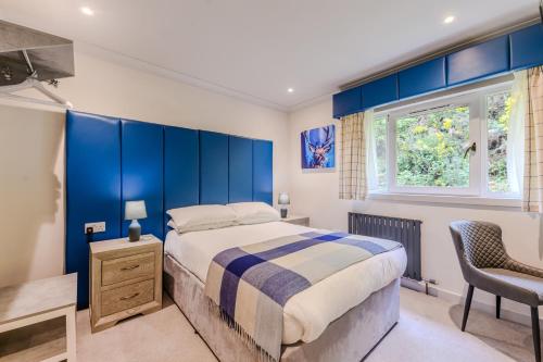 a bedroom with a bed and a blue wall at Loch Ness Clansman Hotel in Drumnadrochit