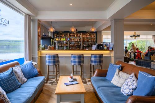 a bar in a restaurant with blue couches at Loch Ness Clansman Hotel in Drumnadrochit