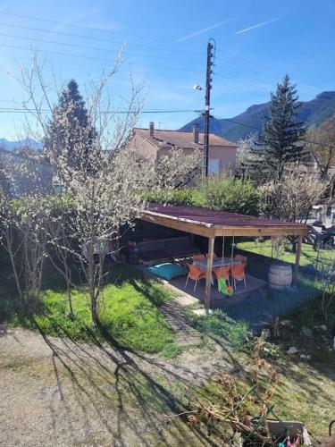 un pavillon dans une cour avec deux chaises en dessous dans l'établissement La Maison JAUNE, à Die