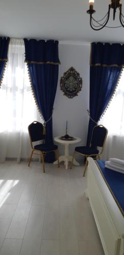 a room with blue curtains and a table and chairs at Vila Bohemia in Sibiu