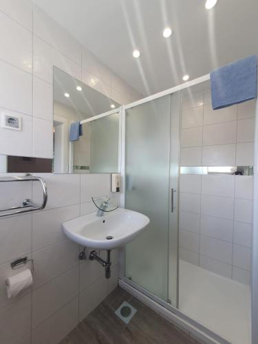 a white bathroom with a sink and a shower at Guesthouse Nikola in Plitvička Jezera