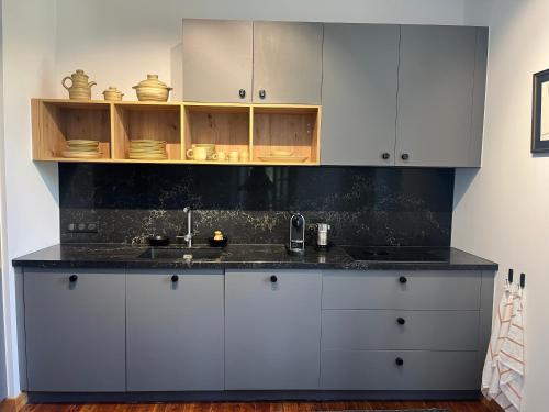 une cuisine avec des armoires blanches et un évier dans l'établissement Magnifique appartement Villa Mexicaine, à Barcelonnette