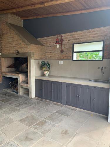 a kitchen with gray cabinets and a fireplace at Casa Norte in Concordia