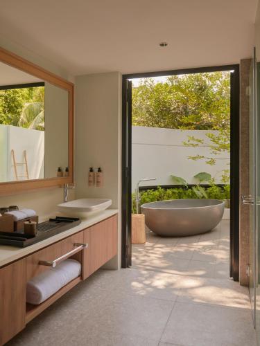 a bathroom with a tub and a large mirror at Amara Sanctuary Sentosa in Singapore
