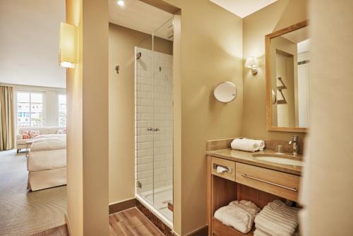 ein Bad mit einem Waschbecken und einer Dusche in der Unterkunft Strandhotel Zingst in Zingst