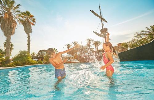 two children playing in the water at a swimming pool at PortAventura Hotel El Paso - Includes unlimited access to PortAventura Park & 1 access to Ferrari Land in Salou