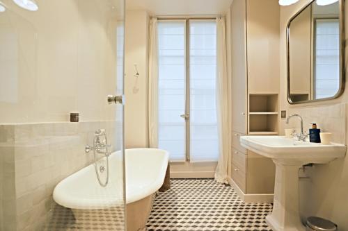 une salle de bain avec une baignoire, un lavabo et une douche dans l'établissement Beautiful apartment Jardin Luxemboug rue Férou, à Paris