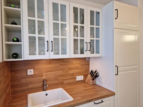 a kitchen with white cabinets and a sink at Sonnenhang im Boho-Stil mit Balkon, 500m zum See, 2 Schlafzimmer in Möhnesee