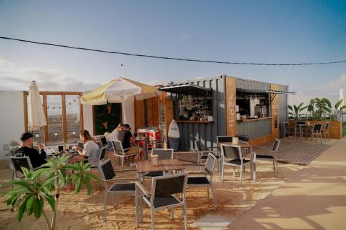 a restaurant with tables and chairs on the beach at Shambhala Fuerteventura in Parque Holandes