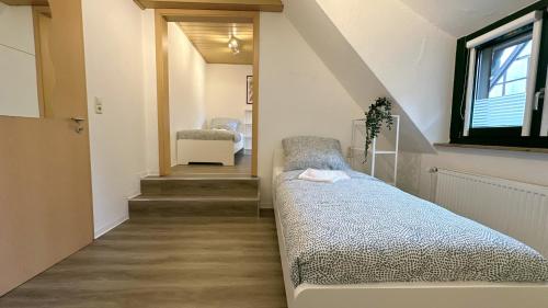a room with a bed and a staircase with a window at Monteurunterkunft Komfort Plus in Hörstel