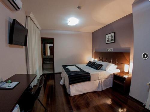 a hotel room with a bed and a desk at Santa Catarina Plaza Hotel in Canoinhas
