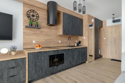 a kitchen with a fireplace and a tv at Eleganckie Studio Basen, Fitness & Balkon by Noclegi Renters in Dziwnów