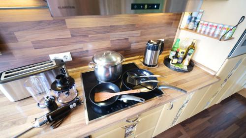 a kitchen counter with pots and pans on a stove at Green Loft Schwarzwald - Dach-Balkon--Musik-Ecke in Winzeln