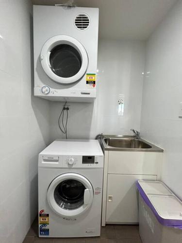 a kitchen with a washing machine and a sink at The River at Parramatta wif Free parking in Sydney
