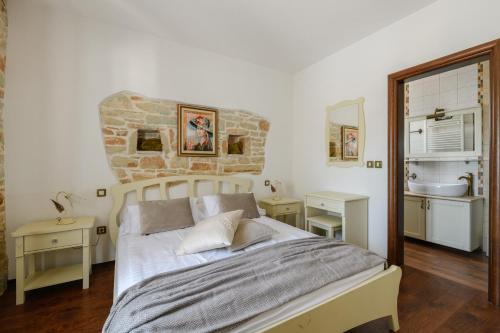 a bedroom with a bed and a stone wall at VILLA GINA in Valtura