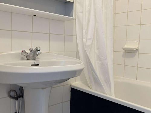 une salle de bain blanche avec un lavabo et une douche dans l'établissement Studio bord de mer, parking, animaux admis - FR-1-229D-226, à Saint Pierre La Mer