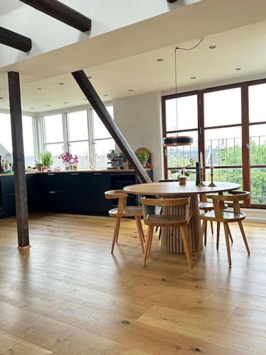 a dining room with a table and chairs in a room at Penthouse med egen tagterrasse in Copenhagen