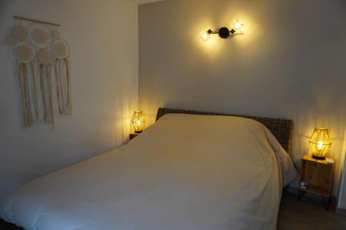 - une chambre avec un lit blanc et deux lumières sur le mur dans l'établissement Jacobins-6 pers-Proche mer-Calme, à Lapalme