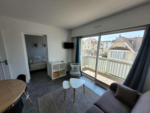 un salon avec un canapé et une grande fenêtre dans l'établissement Appartement soigné à deux pas de la mer, balcon ensoleillé, confort et tranquillité à Wimereux - FR-1-675-37, à Wimereux