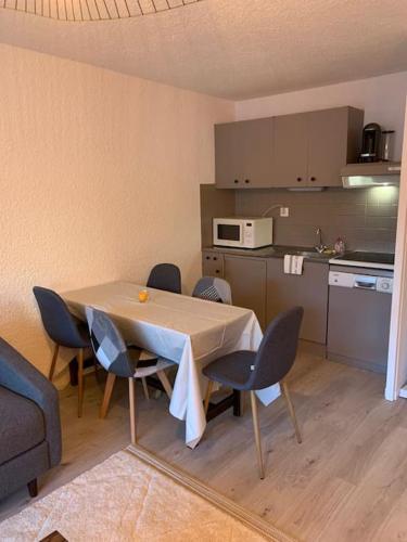 une cuisine avec une table et des chaises dans une pièce dans l'établissement Appartement Alpe d Huez centre, à Huez