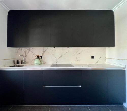 a kitchen with black cabinets and white counter tops at C17A01Moderno apto 3 dormitorios in Ampuero