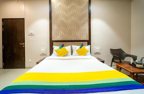 a bedroom with a large bed with colorful pillows at Itsy Hotels Sitara in Satara