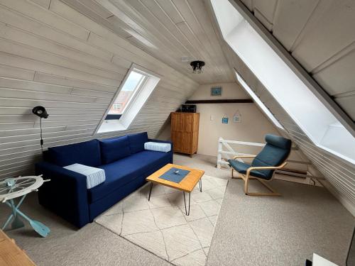 a living room with a blue couch and a table at Altes Zollhaus in Fehmarn