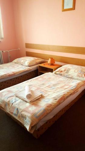 two beds in a hotel room with towels on them at Penzion Premona in Nitra