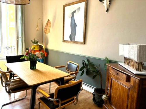 une salle à manger avec une table et des chaises en bois dans l'établissement GRAND APPARTEMENT DE CARACTERE à VICHY, à Vichy