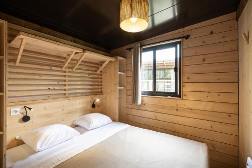 a bed in a wooden room with a window at Citykamp d'Aix-en-Provence in Aix-en-Provence