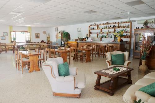 una habitación con sillas y mesas y un bar en Hotel Cesotta en Ischia