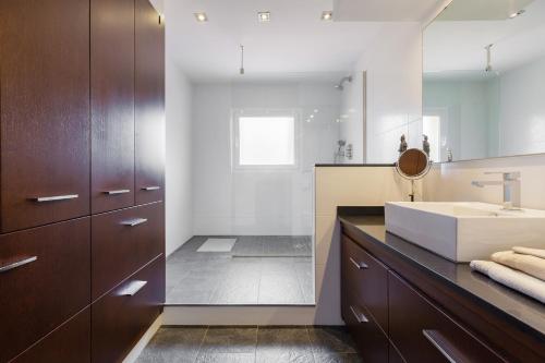 ein Badezimmer mit Waschbecken und großem Spiegel in der Unterkunft Casa con jardín próxima a Barcelona in Sant Andreu de Llavaneres