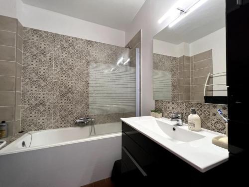 une salle de bain avec une baignoire et un lavabo et une baignoire dans l'établissement T3 centre Narbonne-plage vue Mer, à Narbonne-Plage