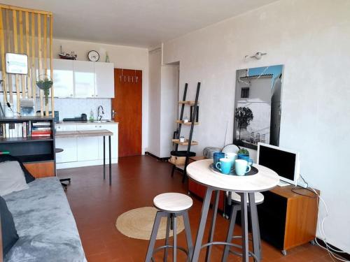 Il comprend un salon avec une petite table et une cuisine. dans l'établissement T3 centre Narbonne-plage vue Mer, à Narbonne-Plage