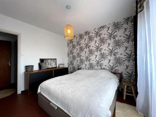 - une chambre avec un lit et du papier peint noir et blanc dans l'établissement T3 centre Narbonne-plage vue Mer, à Narbonne-Plage