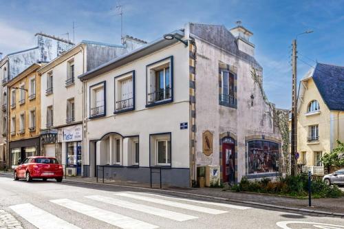 une voiture rouge garée devant un bâtiment dans l'établissement Appartement Heol-Moderne Quatre-moulins, à Brest