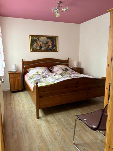una camera con letto in legno e un dipinto sul muro di Altes Zollhaus a Fehmarn