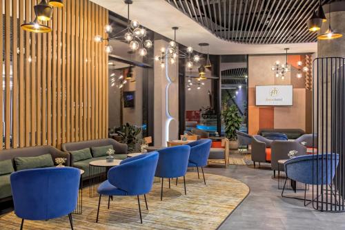 a lobby with blue chairs and tables at Focus Hotel Premium Warszawa in Warsaw