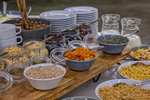 a table topped with bowls of food and plates at Focus Hotel Premium Warszawa in Warsaw