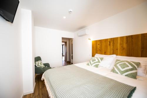 a bedroom with a large bed with a wooden headboard at Mira D'Ouro Sertã in Sertã
