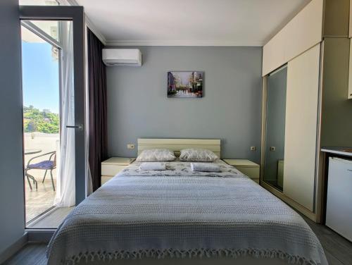 une chambre avec un grand lit et une grande fenêtre dans l'établissement Апартаменты с видом на море и Батуми, à Makhinjauri