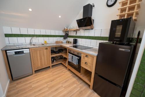 a kitchen with a black refrigerator and wooden cabinets at Mira D'Ouro Sertã in Sertã