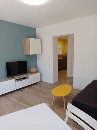 un salon avec un canapé et une télévision dans l'établissement Petite maison dans un écrin de verdure, aux Angles (Gard)