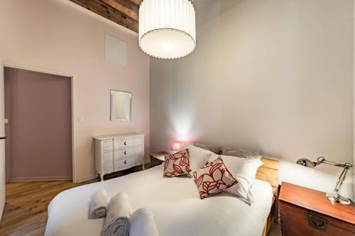 une chambre avec un grand lit blanc avec des oreillers dans l'établissement Le centrale AIL, à Lyon