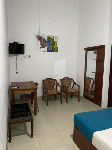 um quarto com uma cama, uma mesa e cadeiras em Why Not Palace em Anuradhapura
