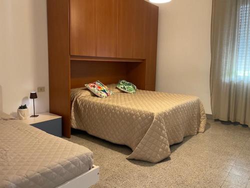 a bedroom with two beds and a headboard at Casa Il Gelso in Cattolica