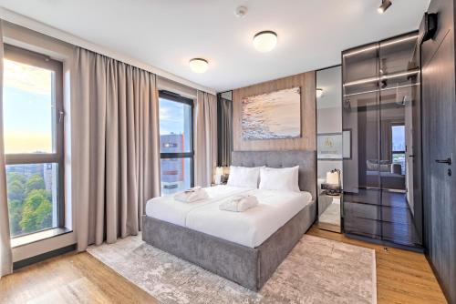 a bedroom with a large bed and windows at Focus Hotel Premium Warszawa in Warsaw
