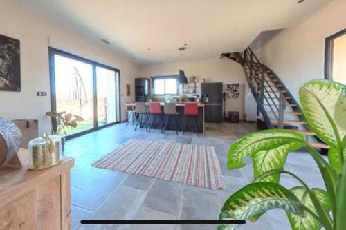 un salon avec un escalier et une salle à manger dans l'établissement Grange au milieu des vignes, à Béziers