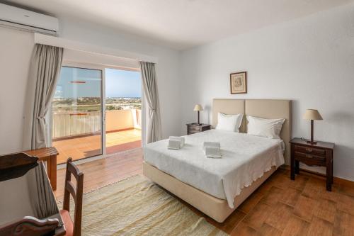 a bedroom with a large bed and a balcony at Parque Monte Verde in Albufeira
