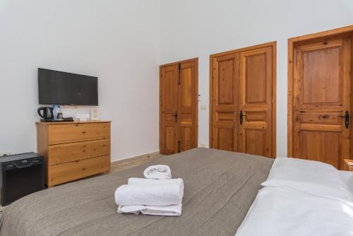 a bedroom with a bed with towels on it at Lebanese Diaspora Village in Batroûn